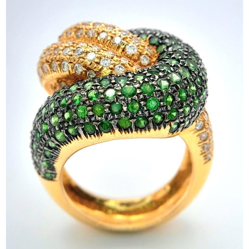 659 - An 18K Yellow Gold, Diamond and Emerald Abstract Ring. Serpent-esque in nature this pave diamond and... 