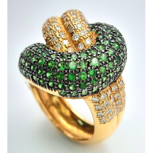 659 - An 18K Yellow Gold, Diamond and Emerald Abstract Ring. Serpent-esque in nature this pave diamond and... 