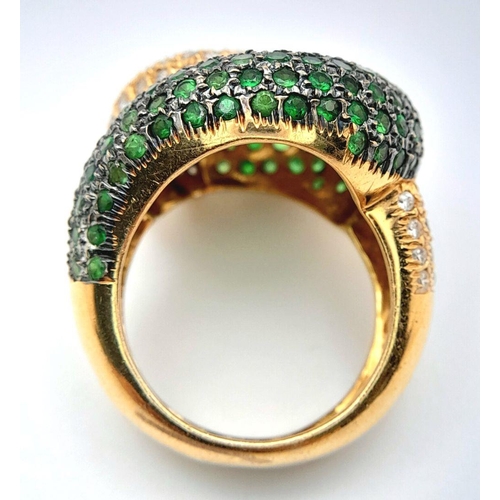 659 - An 18K Yellow Gold, Diamond and Emerald Abstract Ring. Serpent-esque in nature this pave diamond and... 