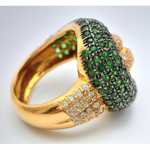 659 - An 18K Yellow Gold, Diamond and Emerald Abstract Ring. Serpent-esque in nature this pave diamond and... 