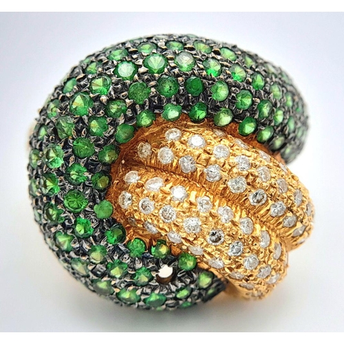 659 - An 18K Yellow Gold, Diamond and Emerald Abstract Ring. Serpent-esque in nature this pave diamond and... 