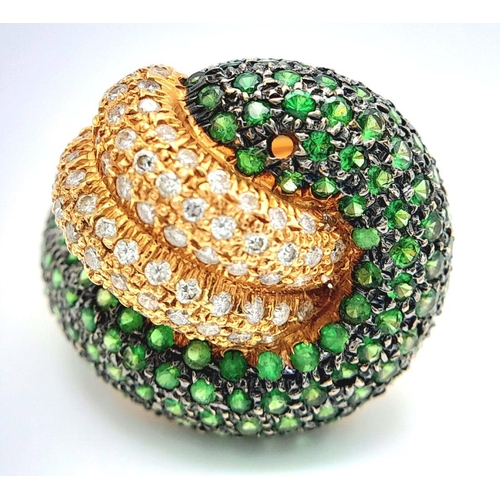 659 - An 18K Yellow Gold, Diamond and Emerald Abstract Ring. Serpent-esque in nature this pave diamond and... 