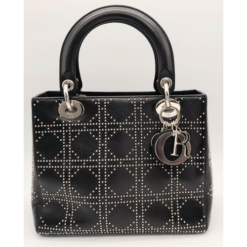 645 - A Christian Dior Black Lady Dior Handbag. Leather exterior with silver-toned hardware, stud embellis... 