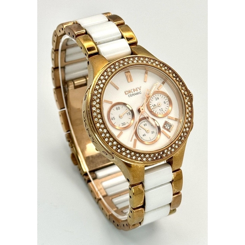 1164 - A rose gold plated, Ceramic DKNY Chronometer watch, 38 mm case, bezel with cubic zirconia, white dia... 