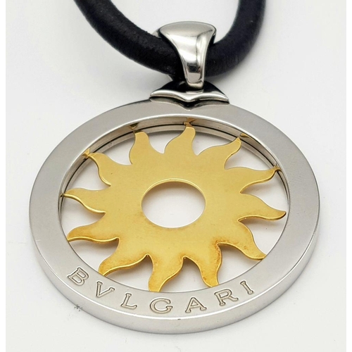 617 - A Bulgari Steel and 18K Yellow Gold Sun Pendant. 4.5cm diameter.  Textile necklace. Comes with origi... 