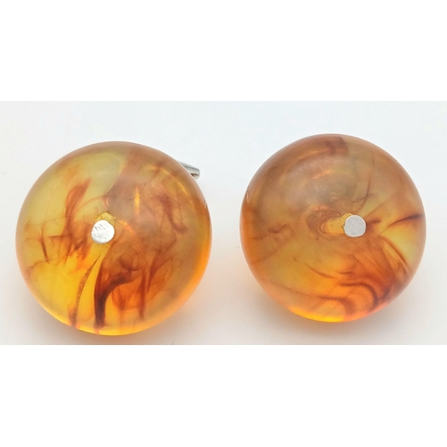 1416 - A pair of amber resin cufflinks. Comes with box. 13g in weight.