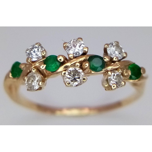 71 - A 14K Diamond and Emerald Crossover Ring. Size M 1/2. 1.88g total weight. Comes with a case.