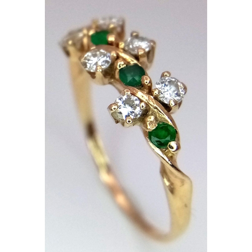 71 - A 14K Diamond and Emerald Crossover Ring. Size M 1/2. 1.88g total weight. Comes with a case.