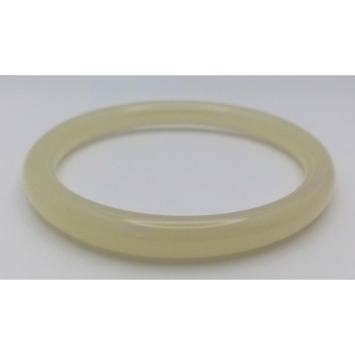 815 - A Thin Green Pale Jade Fashion Jade Bangle. 7mm width. 6cm inner diameter.