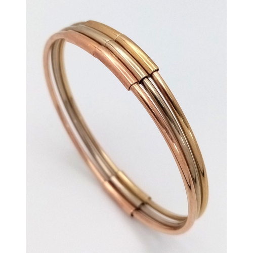 17 - A Fancy Italian 9K Tri-Colour Gold Bangle. Yellow, white and rose gold bars. 58mm inner diameter. 9.... 