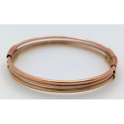 17 - A Fancy Italian 9K Tri-Colour Gold Bangle. Yellow, white and rose gold bars. 58mm inner diameter. 9.... 