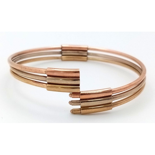 17 - A Fancy Italian 9K Tri-Colour Gold Bangle. Yellow, white and rose gold bars. 58mm inner diameter. 9.... 