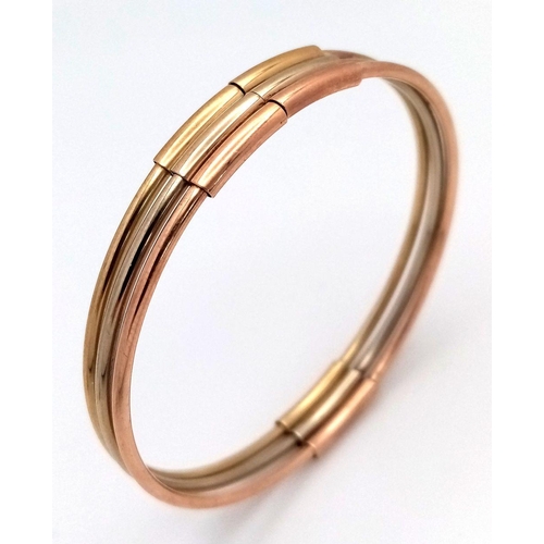 17 - A Fancy Italian 9K Tri-Colour Gold Bangle. Yellow, white and rose gold bars. 58mm inner diameter. 9.... 