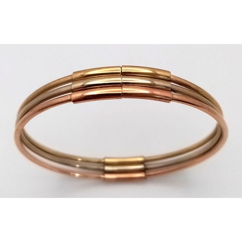 17 - A Fancy Italian 9K Tri-Colour Gold Bangle. Yellow, white and rose gold bars. 58mm inner diameter. 9.... 