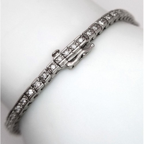 212 - A 10K White Gold Diamond Tennis Bracelet. 65 small round cut diamonds. 19cm length. 10.25g total wei... 