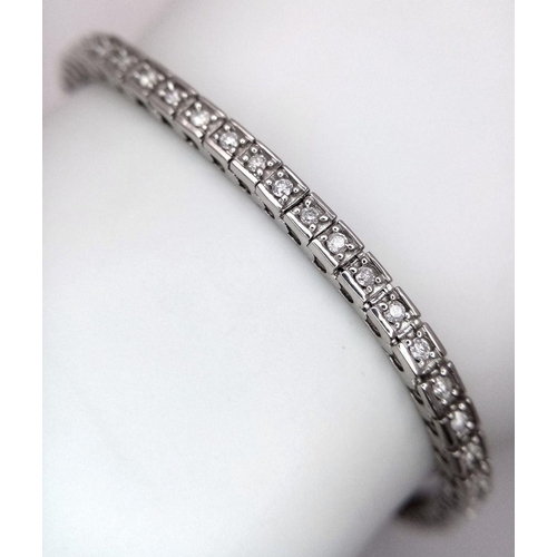 212 - A 10K White Gold Diamond Tennis Bracelet. 65 small round cut diamonds. 19cm length. 10.25g total wei... 