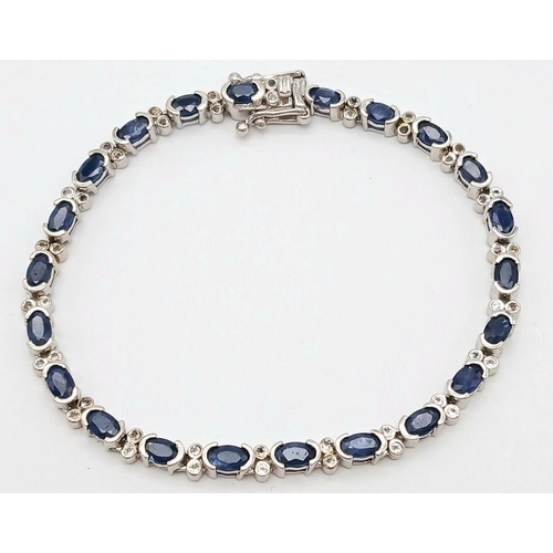 592 - Sterling Silver Sapphire Set Tennis Bracelet. 19cm Length. Set with Twenty-Two 5mm Oval Cut Sapphire... 