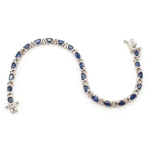 592 - Sterling Silver Sapphire Set Tennis Bracelet. 19cm Length. Set with Twenty-Two 5mm Oval Cut Sapphire... 