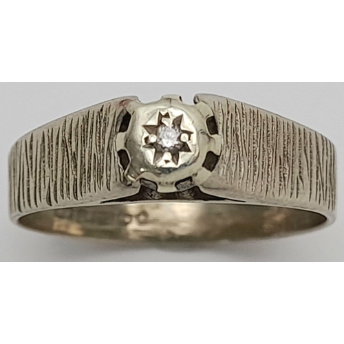 155 - A Vintage 9K White Gold Diamond Solitaire Ring. A small round cut diamond with bark effect shoulders... 