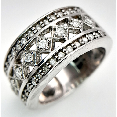 261 - A 9K WHITE GOLD DIAMOND SET FANCY DESIGN WIDE BAND RING 0.25CT 8.37G SIZE O. Ref: SC 4016