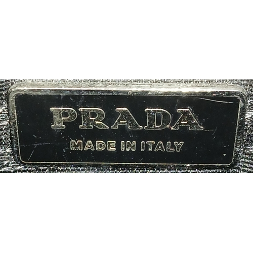 298 - A Prada Black Textile Hand/Shoulder bag. Black leather trim and handles. Removable shoulder strap. T... 