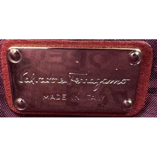 326 - A Salvatore Ferragamo Red Leather Handbag. Saddle form silver tone hardware. Purple textile interior... 