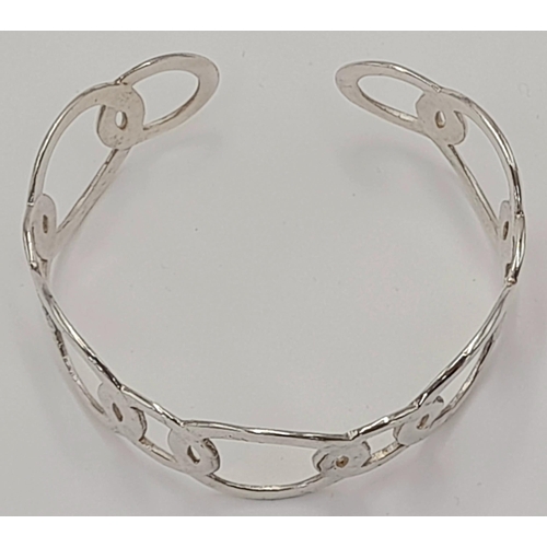 818 - A STERLING SILVER CIRCLES DESIGN BANGLE. TOTAL WEIGHT APPROX. 22G. Ref: SC 4090