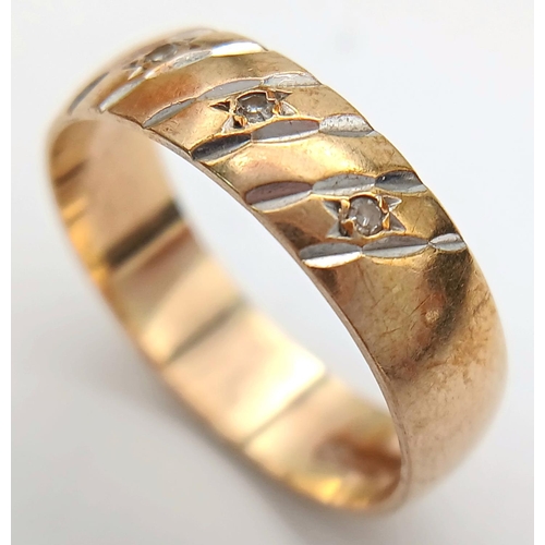 1012 - A 9K Yellow Gold Diamond Band Ring. Full UK hallmarks. Three small round cut diamonds. Size O 1/2. 3... 