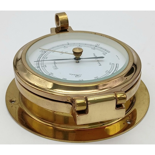 167 - A nautical, polished brass, KELVIN HUGHES   barometer, having the shape of a ship-cabin’s porthole, ... 