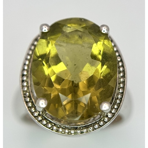 420 - Large oval cut YELLOW TOURMALINE set in a SILVER RING. Having markings for 925 SILVER and TGGC ( The... 