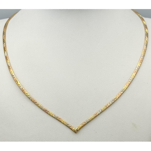 569 - An 18K Yellow, White and Rose Gold Herringbone Necklace. 
38cm. 14.9g.