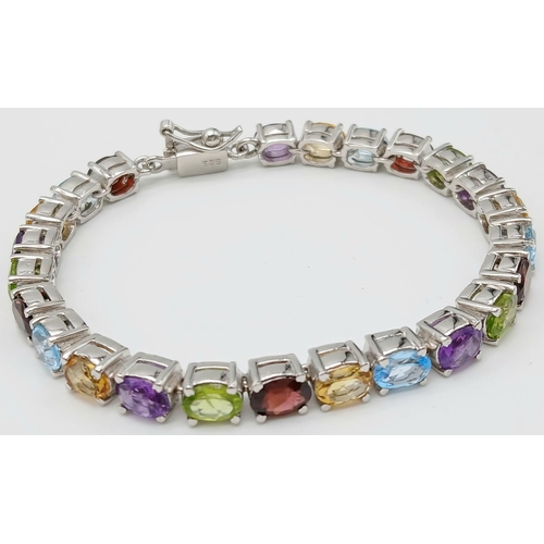 970 - An Oval Cut Amethyst, Peridot and Citrine Gemstone Tennis Bracelet. Set in 925 Silver. 18cm length. ... 