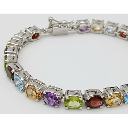 970 - An Oval Cut Amethyst, Peridot and Citrine Gemstone Tennis Bracelet. Set in 925 Silver. 18cm length. ... 