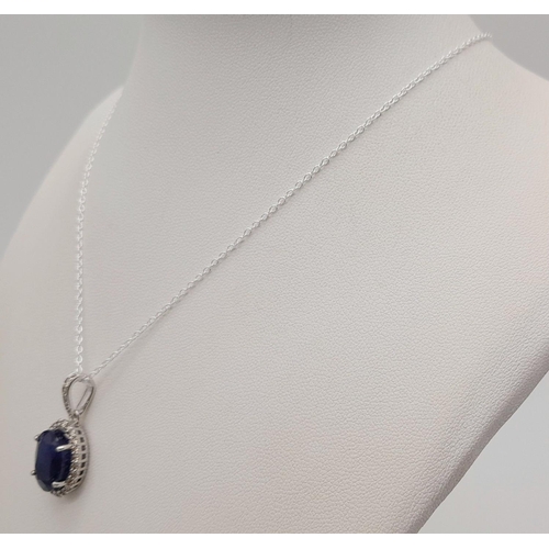 611 - A 6ct Blue Sapphire Pendant with 0.62ctw of Diamond Accents. Set in 925 Silver. 25mm.