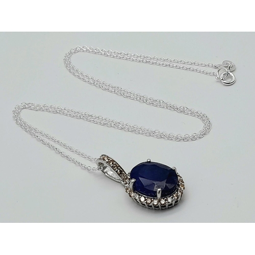 611 - A 6ct Blue Sapphire Pendant with 0.62ctw of Diamond Accents. Set in 925 Silver. 25mm.