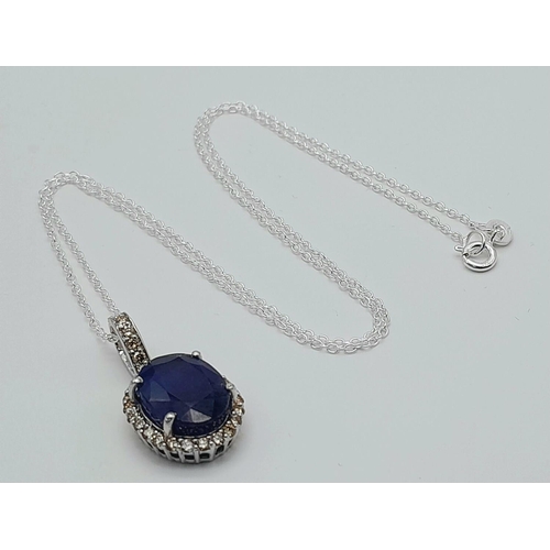 611 - A 6ct Blue Sapphire Pendant with 0.62ctw of Diamond Accents. Set in 925 Silver. 25mm.