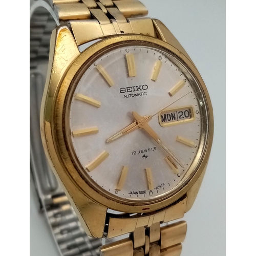 724 - A Vintage Seiko Automatic Gents Watch. Gilded bracelet and case - 36mm. Silver tone dial with day/da... 