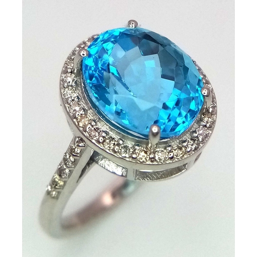 1561 - A 5ct Oval-cut Blue Topaz Ring surrounded by halo of 0.60ct diamonds accent. Set in 925 Silver. Ring... 