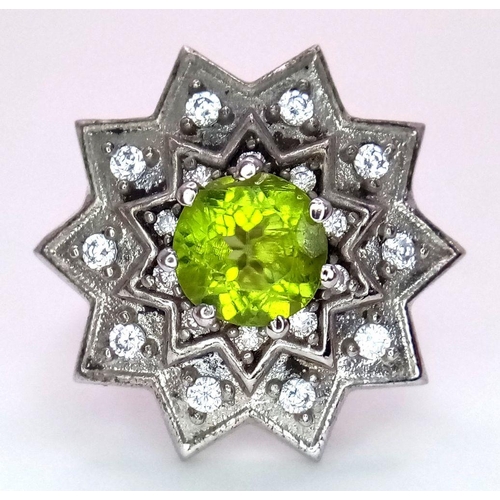 1102 - A 925 Silver ring featuring a vibrant Peridot gemstone at its center, set in an intricate starburst ... 