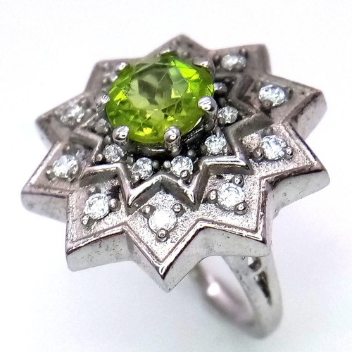 1102 - A 925 Silver ring featuring a vibrant Peridot gemstone at its center, set in an intricate starburst ... 