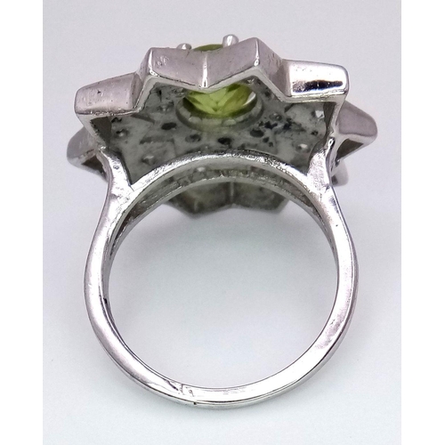 1102 - A 925 Silver ring featuring a vibrant Peridot gemstone at its center, set in an intricate starburst ... 