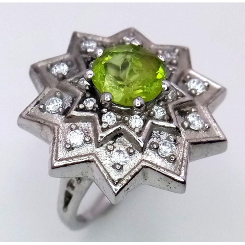 1102 - A 925 Silver ring featuring a vibrant Peridot gemstone at its center, set in an intricate starburst ... 