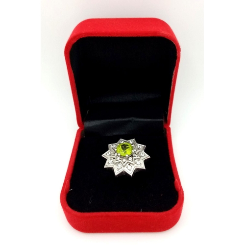 1102 - A 925 Silver ring featuring a vibrant Peridot gemstone at its center, set in an intricate starburst ... 