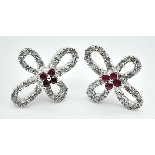 1168 - An Pair of 18K White Gold, Ruby and Diamond Floral Shape Earrings. No backs. 3.63g total weight.