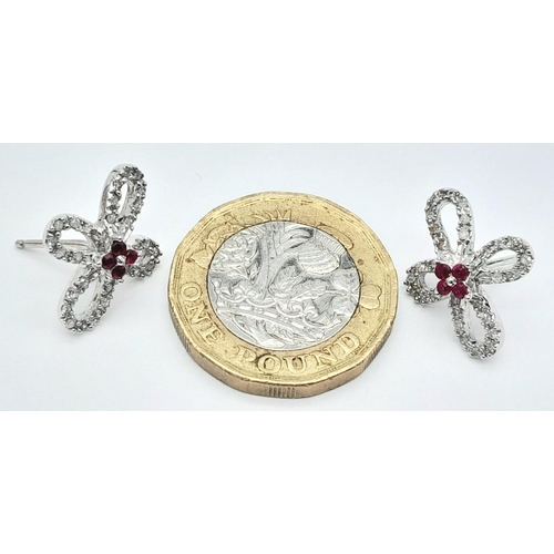 1168 - An Pair of 18K White Gold, Ruby and Diamond Floral Shape Earrings. No backs. 3.63g total weight.