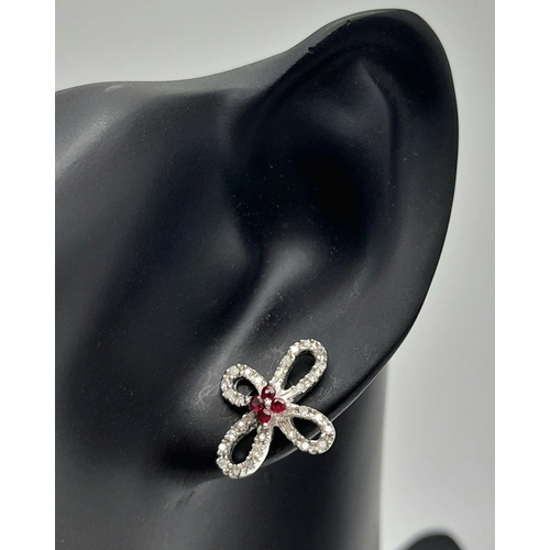 1168 - An Pair of 18K White Gold, Ruby and Diamond Floral Shape Earrings. No backs. 3.63g total weight.