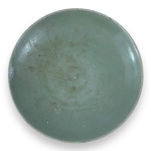 1247 - An antique Chinese Celadon Glazed porcelain Plate. Moderate wear with minor scuffs, a chipped area n... 