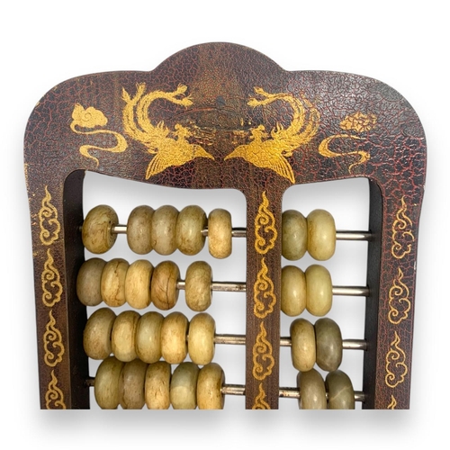 779 - An antique Chinese Jade Abacus (calculator). Hand-carved jade beads set on brass rods, framed in a w... 