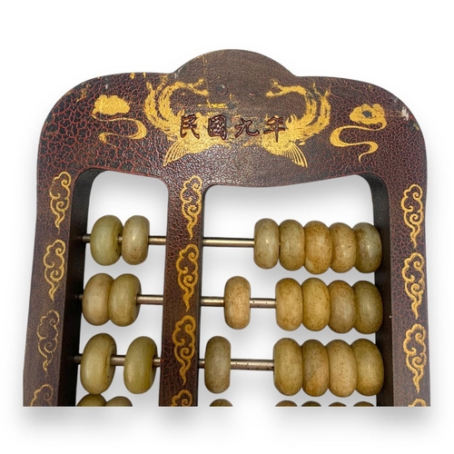 779 - An antique Chinese Jade Abacus (calculator). Hand-carved jade beads set on brass rods, framed in a w... 