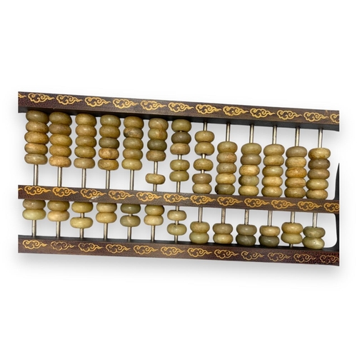 779 - An antique Chinese Jade Abacus (calculator). Hand-carved jade beads set on brass rods, framed in a w... 